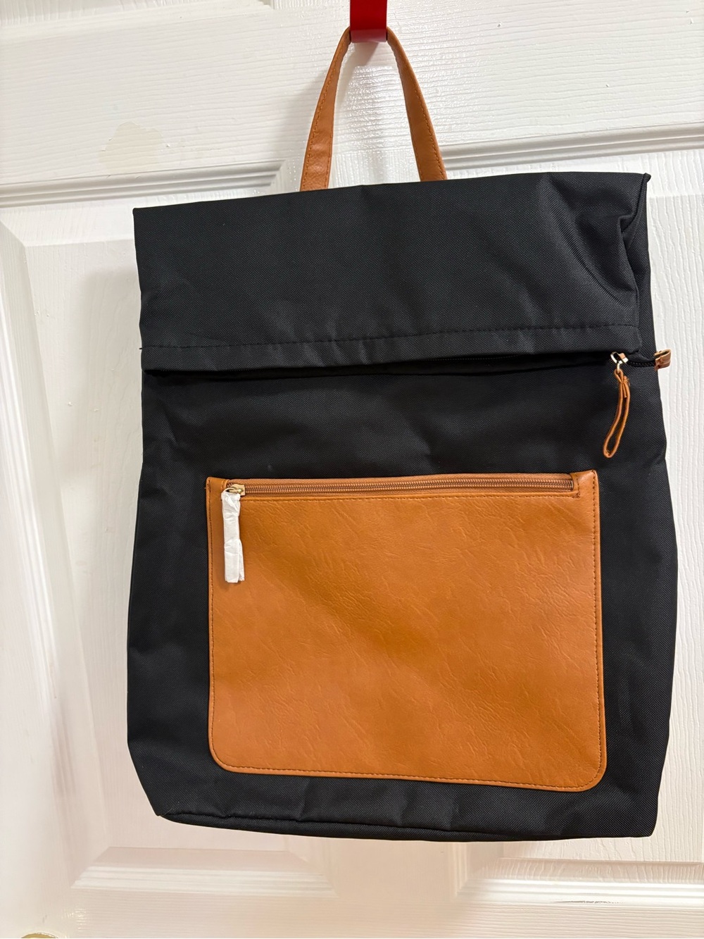 DSW Canvas Backpack features a black fabric body with a faux leather pocket
